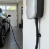 Power and data cable feeding a wall-mounted EV charger in a residential garage Power and data cable feeding a wall-mounted EV charger in a residential garage