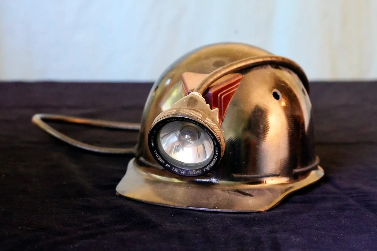 Coal miner's hard hat with a cap lamp on the front, the type of lamp an MGM 101 cable supplies from a belt battery