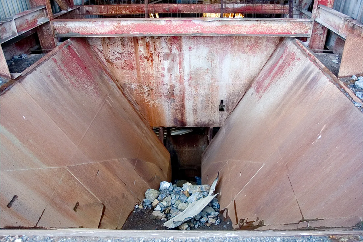 Steel feed hopper above a rock crusher at a mine plant, the kind of crushing equipment an MGM 112 Type 201 or 211 cable supplies at 660/1100 V
