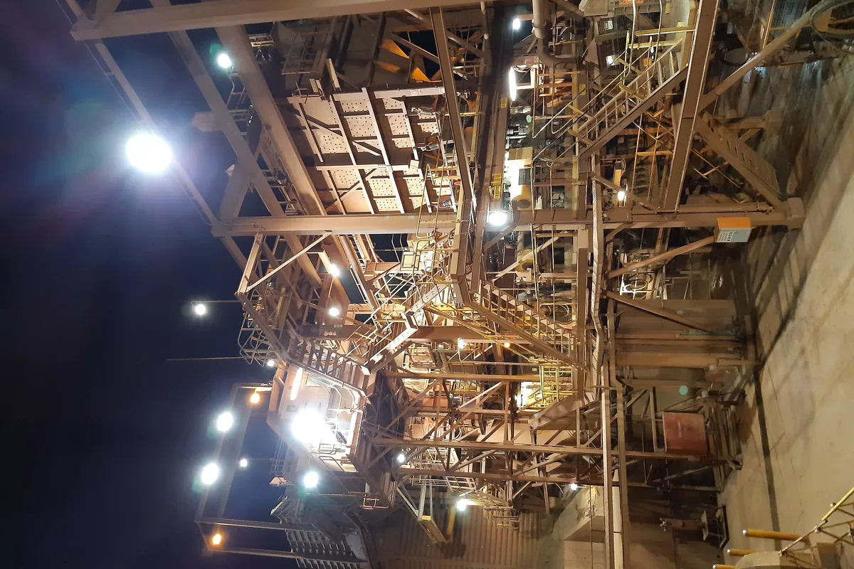 Primary crusher station of an iron ore mine lit at night, the kind of crushing plant an MGM 115 Type 16 trailing cable supplies