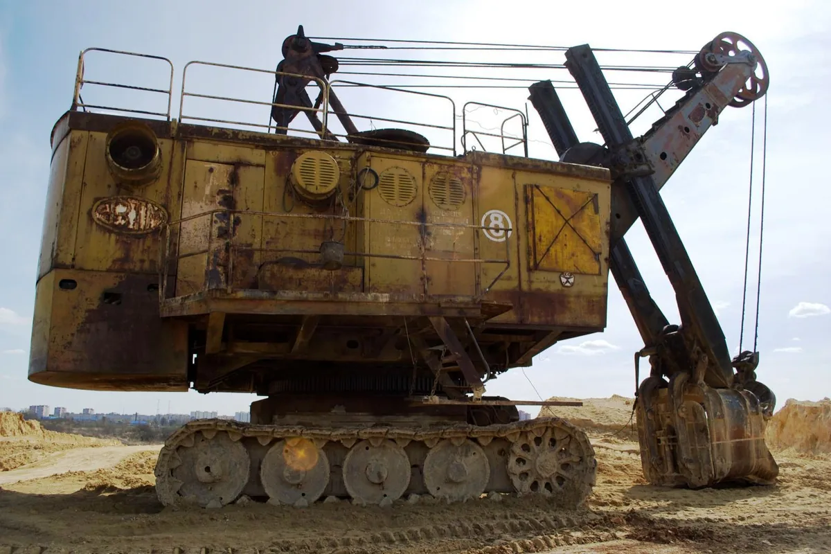 Electric rope shovel excavator on crawler tracks at an open-pit mine, the kind of excavating machine an MGM 115 Type 7 trailing cable supplies