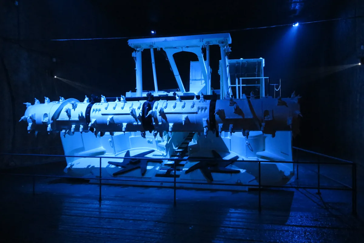 Continuous miner in an underground salt mine gallery with its flexible supply cable, the kind of mobile machine an MGM 115 Type 7M trailing cable feeds