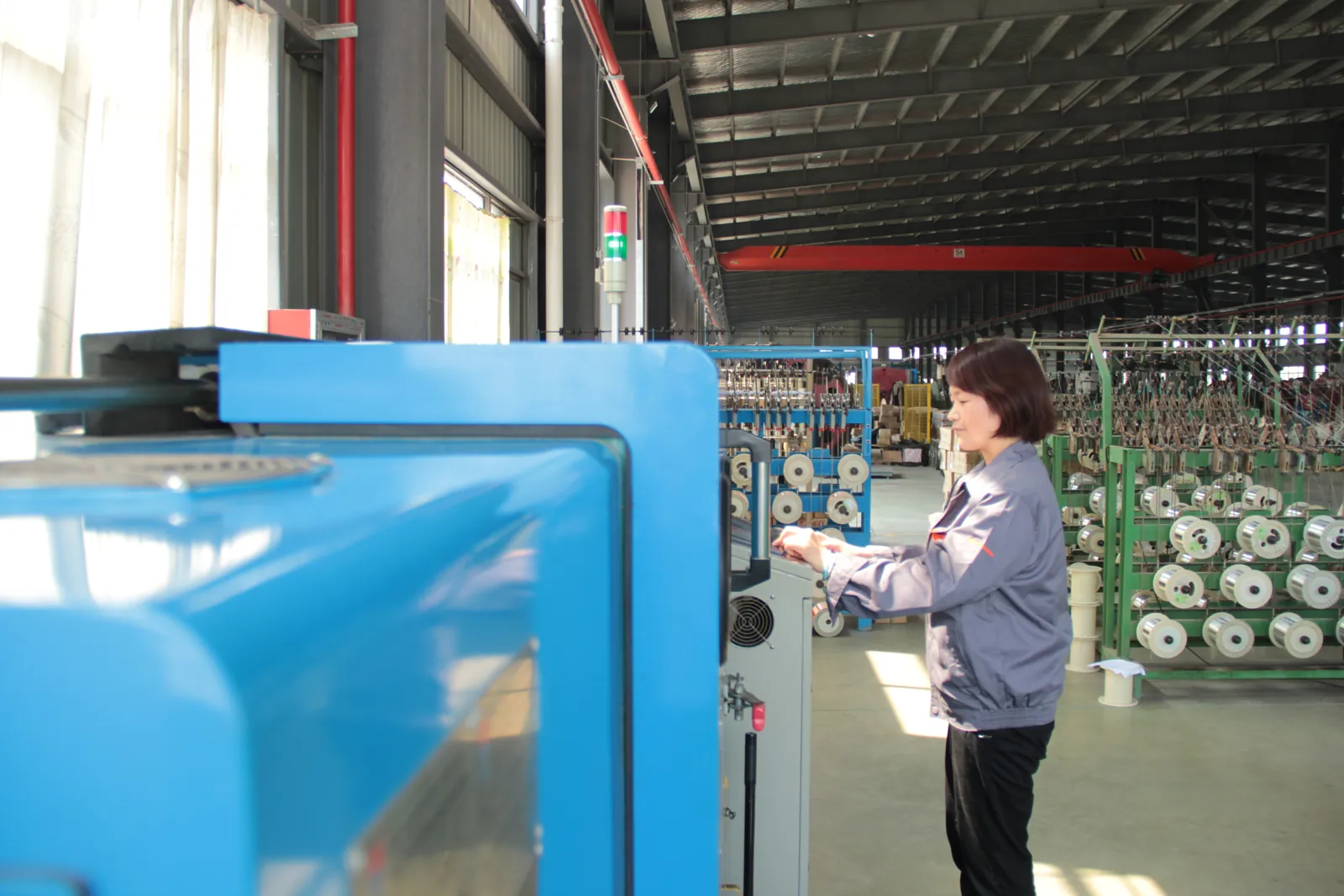 Operator monitoring an extrusion line control panel in the TEBAOFLEX workshop