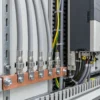 Screened control cables fixed to an earth bar with EMC shield clamps