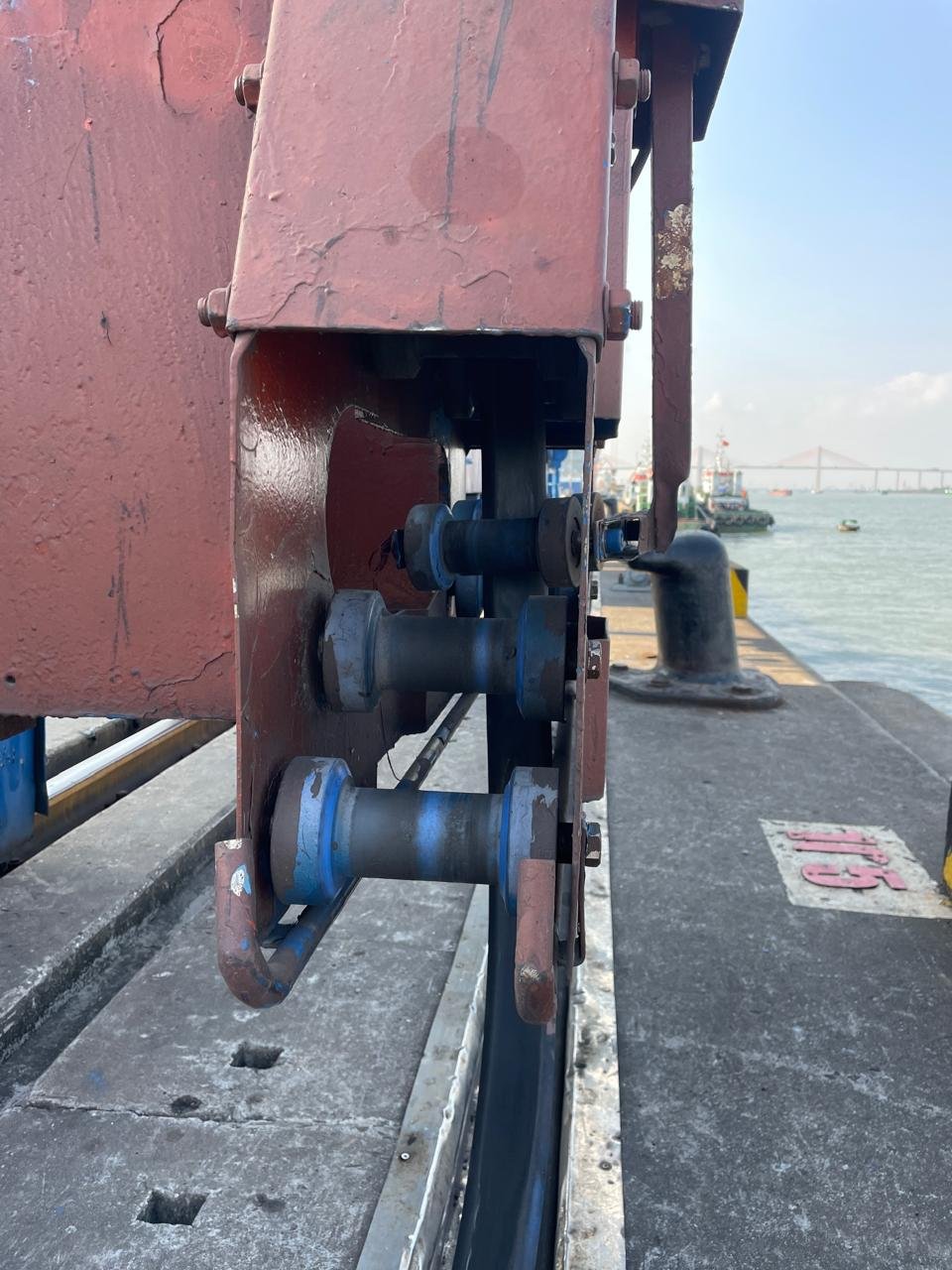 Black cable passing through a guide roller assembly beside the waterfront