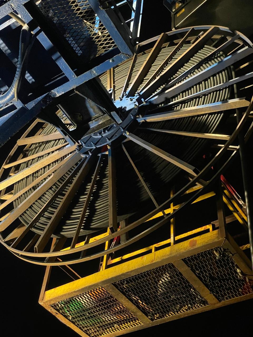 Black cable wound around a large reel mounted within port equipment