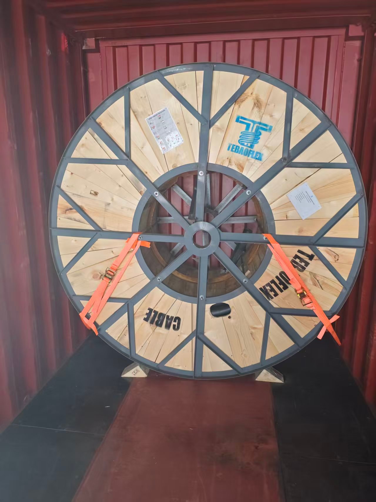 TEBAOFLEX cable drum secured inside a container with orange straps and timber chocks