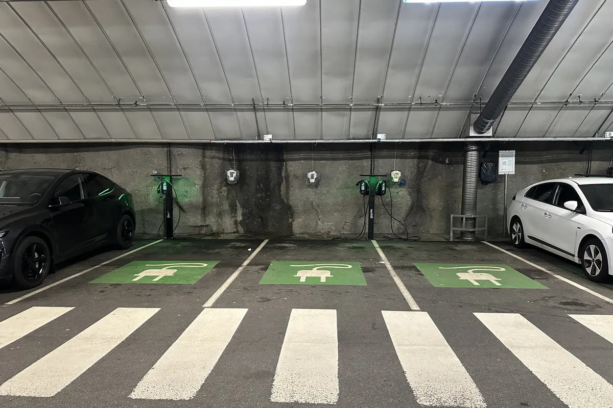 Underground car park with wall-mounted EV charging points above marked charging bays, a typical indoor route for an LSZH power and Cat6A data cable
