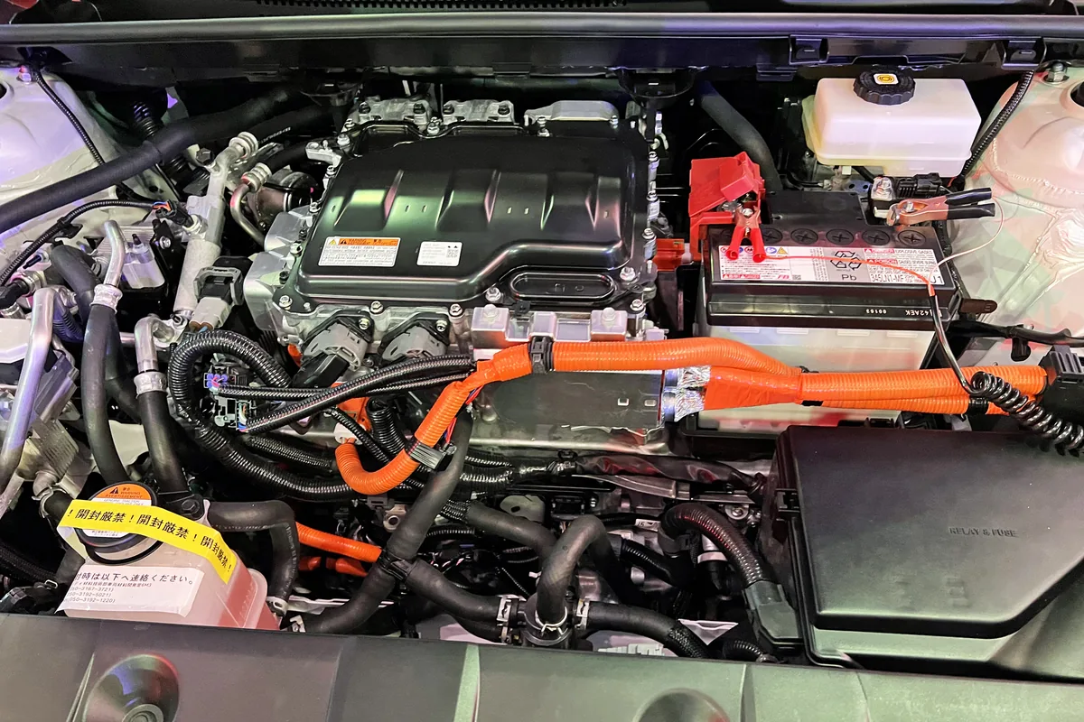 Power inverter mounted on an electric car's drive motor with orange high-voltage cables, the kind of route where HLR2GCB2G shielded silicone cable is used
